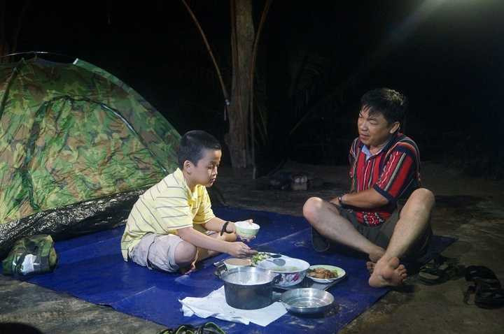 Hai cha con tự giăng lều và nấu ăn buổi tối.