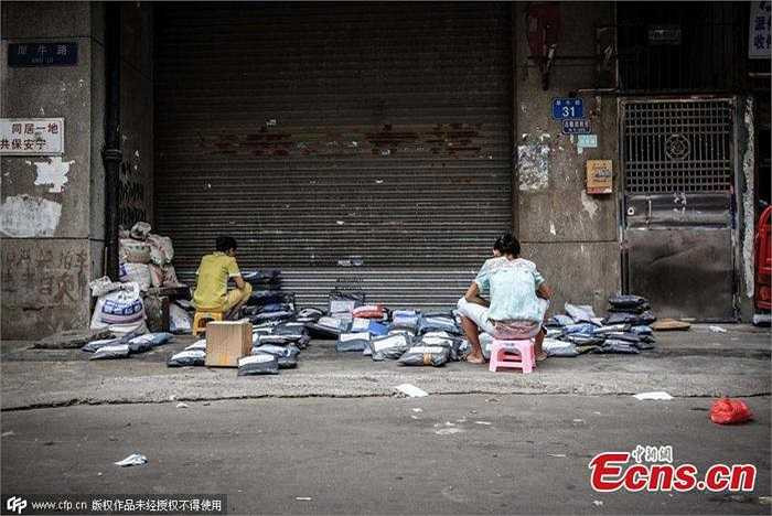 Còn hai người phụ nữ này đang kiểm tra lại số hàng hóa đã giao nhưng bị trả lại. Có thể thấy rất nhiều công ty nhỏ kinh doanh dịch vụ chuyển phát nhanh ở làng Xiniujiao. 