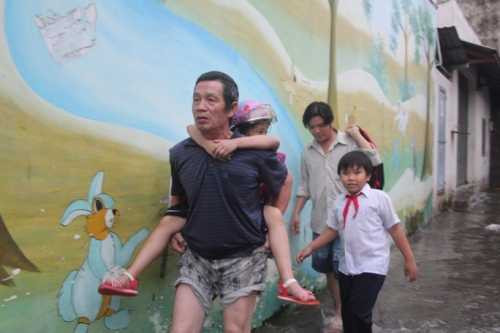 TP.HCM mưa ngập, phụ huynh bì bõm cõng con về