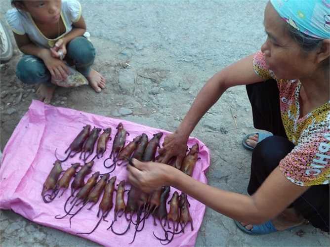 Người phụ nữ xếp từng con chuột đã được thui vàng cho ngay ngắn, thẳng hàng.