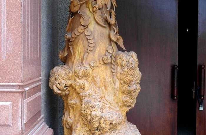 Một bình hoa khổng lồ bằng gỗ, đá chạm khắc nhiều họa tiết sinh động nằm ngay cổng phụ.