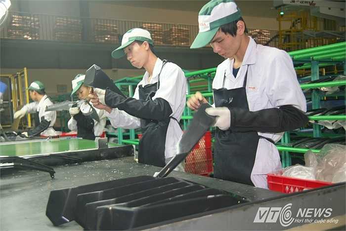 Kỹ thuật viên của nhà máy kiểm tra chi tiết nhựa, xử lý ba-via để đảm bảo các sản phẩm đều nhẵn nhụi ở các mép cạnh.