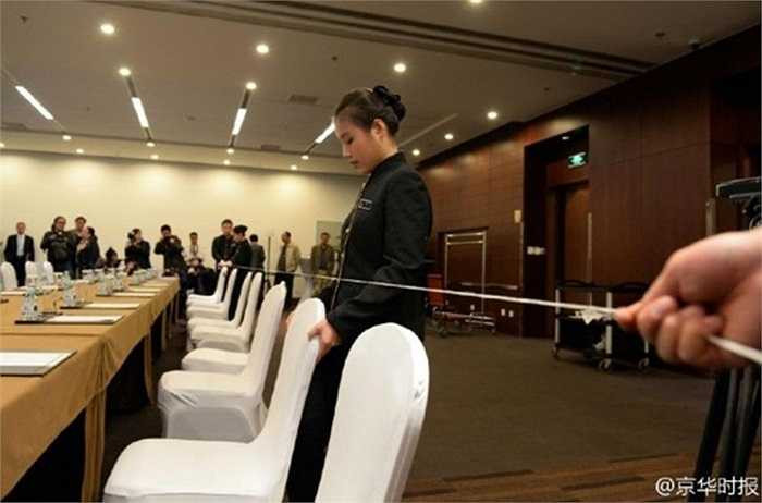 Nữ nhân viên chỉnh sửa vị trí từng chiếc ghế