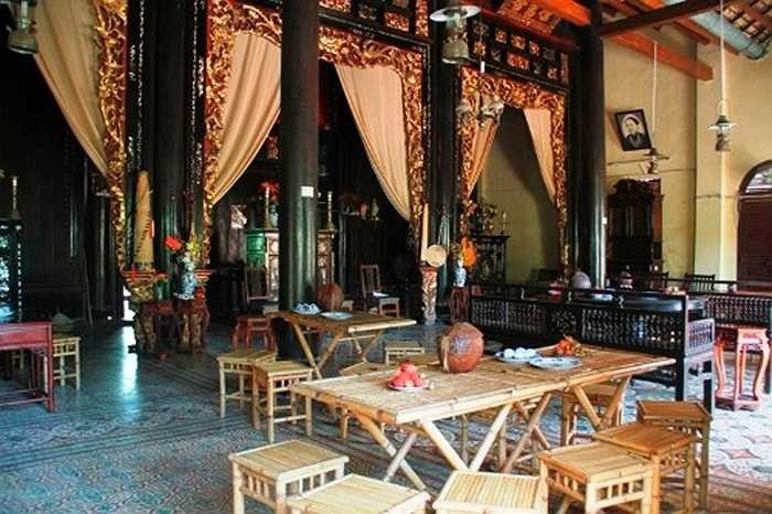 Nội thất được làm từ các loại gỗ quý và bài trí theo phong cách phương Đông với các bức hoành phi câu đối, khắc chạm tinh tế hình long, phụng, bàn ghế nâu gụ vẫn còn nguyên độ sáng bóng. Ảnh: Kim Dung. 