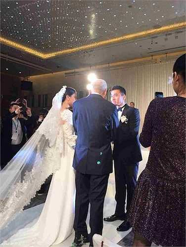 Cao Viên Viên trong bộ váy cưới trang nhã, lộng lẫy được cha dẫn lên sân khấu.