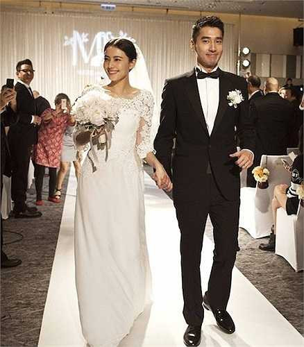 Đôi vợ chồng mới cưới tay trong tay trước sự chứng kiến của mọi người.