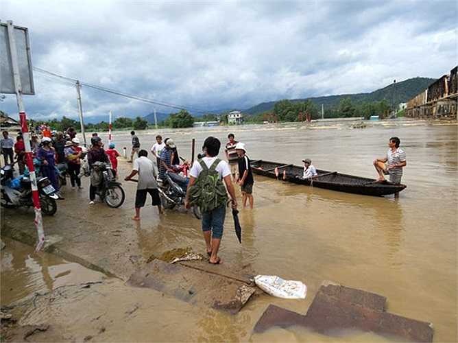 Người dân tìm cách đưa xe qua vùng bị nước lũ chia cắt huyện Đồng Xuân (Phú Yên)-Ảnh: Tuổi trẻ