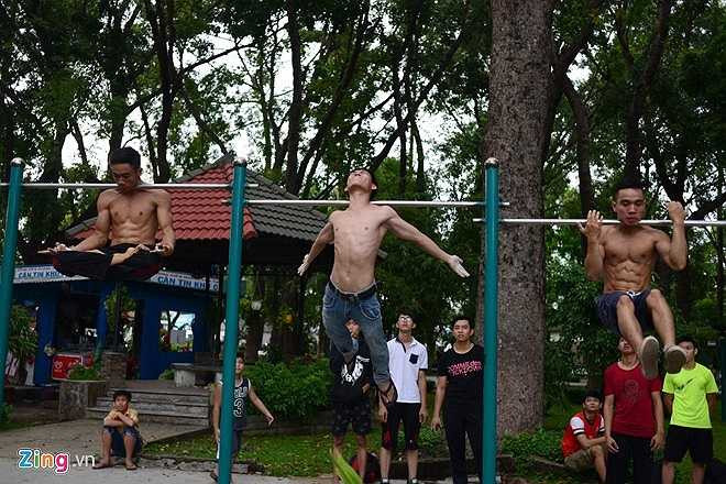 Môn thể thao street workout chia làm hai phần tập cơ bản và nâng cao. Những người mới tham gia sẽ được các thành viên có kinh nghiệm hướng dẫn các bài tập. Trong ảnh: Nhóm Sài Gòn Calisthenics đang thực hiện động tác treo người trên xà bằng gáy.