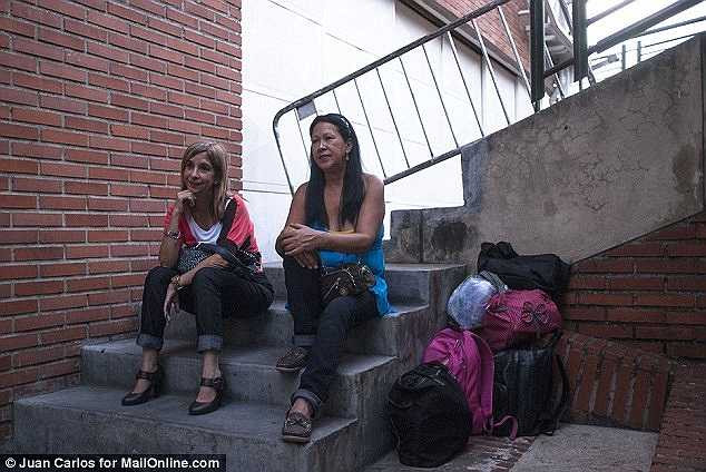 Hình ảnh 2 bậc phụ huynh đang đợi con gái của họ bên ngoài học viện. 