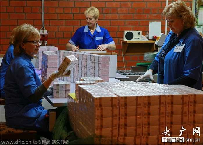 Những nhân viên đóng gói các cọc tiền cẩn thận trước khi tung ra thị trường tiêu thụ