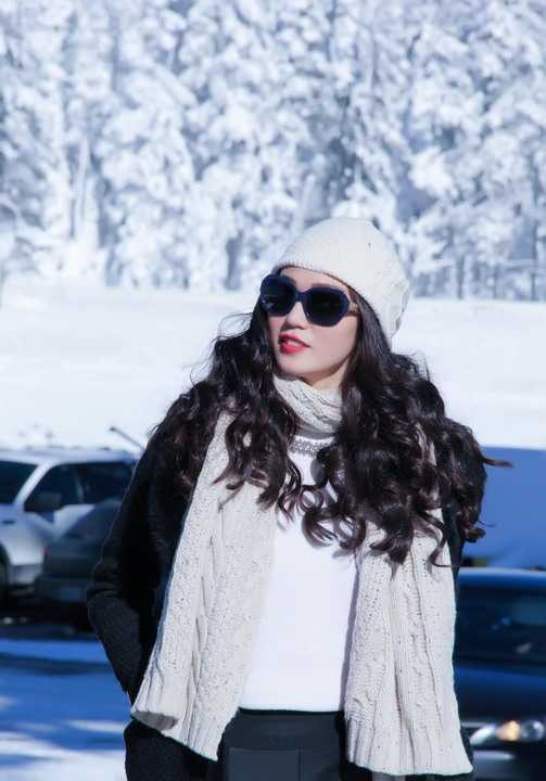 Vì thời tiết khá lạnh nên Khánh My chọn cho mình tregging da, áo thun trắng cổ lọ, áo khác măng tô dày phối cùng mũ và khăng choàng đỏ nổi bật và ấm áp. Từ chỗ Khánh My ở đến chỗ có tuyết phải mất 2 tiếng đi xe