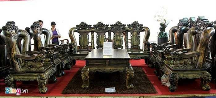 6. Tại một hội chợ nội thất tại trung tâm triển lãm Tân Bình (TP.HCM), bộ salon gồm 4 ghế đơn cao 1,7 m nặng hơn 300 kg, 1 băng ghế dài cao 1,7 m nặng hơn 1 tấn, 1 bàn trà lớn, 2 bàn trà nhỏ, 2 ghế đôn được làm từ gỗ mun hoa chào bán với giá tiền tỷ. Ảnh: Zen Nguyễn. 
