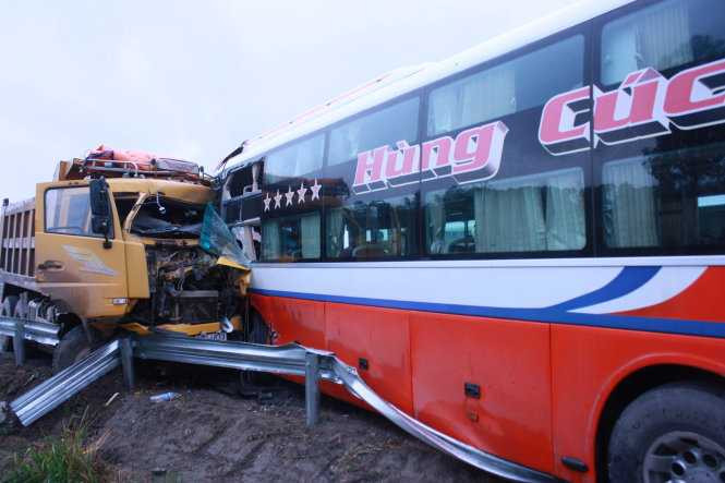 Xe tải tông nát đầu xe khách, 2 tài xế kẹt cứng trong cabin