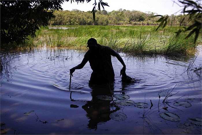Người thợ săn có tên Robert Gaykamangu này vừa bắn được một con ngỗng khi băng qua con sông cụt trên đường đi.