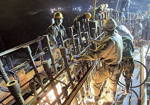 Lắp đặt mối nối cốt thép thân trụ cầu chính. Tiến độ là một trong những yếu tố quyết định, việc thi công ban đêm là chuyện thường đối với dự án cầu Nhật Tân .