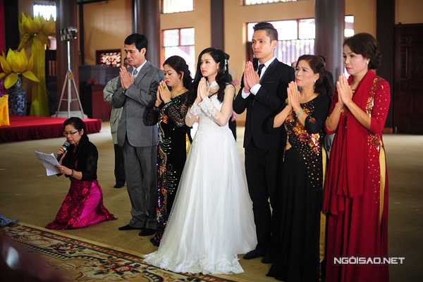 Cặp đôi và người thân thành tâm trước ban thờ Phật.