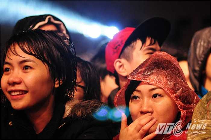 Khán giả đội ô, mặc áo mưa nghe nhạc.