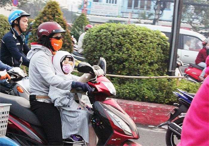 Ngoài trang bị các các vật dụng chống rét cho 'thiên thần', phụ huynh này còn lấy khăn để choàng lên người em nhằm giữ ấm tốt nhất cho bé khi ra đường.