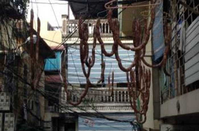 Lạp xưởng là món ăn khá quen thuộc với người Việt. Thông thường, sau khi hoàn thành các công đoạn chế biến và trộn nguyên liệu lại với nhau rồi cho vào ruột lợn thì công đoạn cuối là treo từng xâu lạp xưởng trong lò để sấy bằng than, hoặc cho vào máy sấy công nghiệp để lạp xưởng sẽ khô từ ngoài vào tận giữa ruột. Tuy nhiên, thay vì chọn cách sấy đảm bảo, lạp xưởng tại đây lại được phơi khô kiểu... tự nhiên