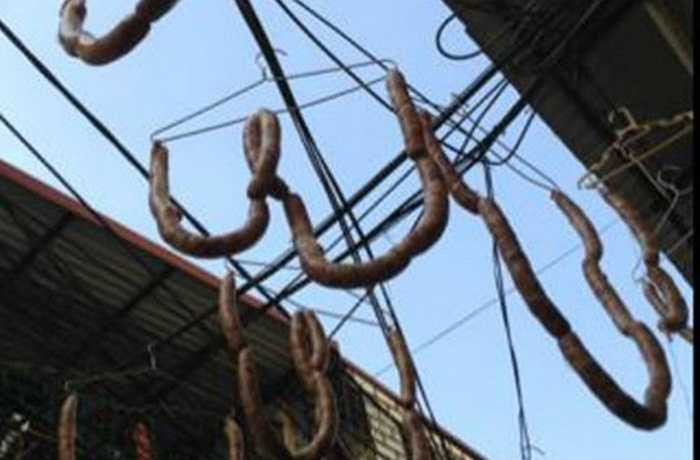 Tại khu vực ngõ 58, đường Hoàng Hoa Thám,người chế biến móc từng khúc lạp xưởng vào móc áo rồi đem treo trên...dây điện để phơi khô.