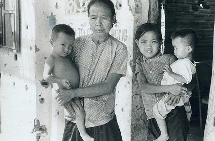 Cư dân Xóm Suối bên ngôi nhà lỗ chỗ vết đạn do các cuộc giao tranh đầu năm 1973, trước khi Hiệp định Paris được ký kết