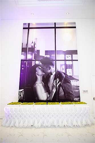 Trước sảnh tiệc trang trí rất nhiều ảnh cưới của đôi vợ chồng mới cưới. Một trong những kiểu ảnh lãng mạn, thể hiện tình cảm nồng cháy của nữ người mẫu và chồng Việt kiều được đặt long trọng ở khu vực đón khách. 