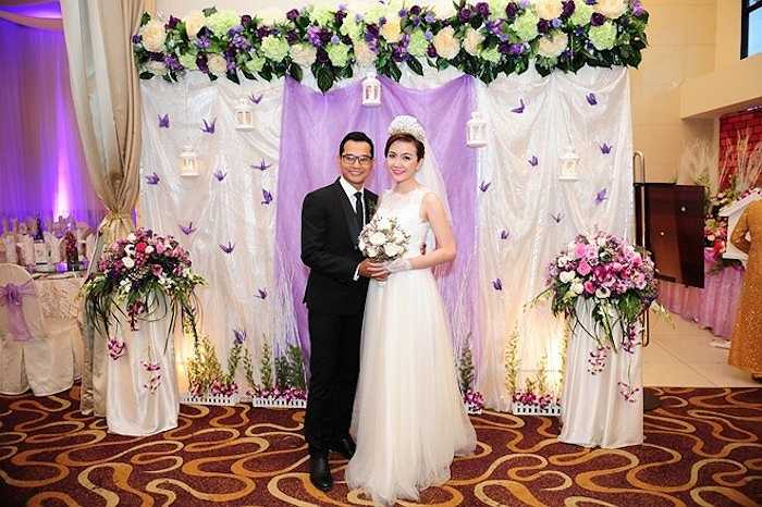 Không gian tiệc cưới của nam diễn viên Gọi giấc mơ về được trang trí với tông màu chủ đạo là trắng tím. Từ sảnh tiệc cho đến khu vực chụp ảnh đều được trang hoàng cầu kỳ với những lẵng hoa gam màu hồng, tím nổi bật giữa nền vải trắng. Đôi vợ chồng trẻ tranh thủ chụp ảnh kỷ niệm trước giờ đón khách. 