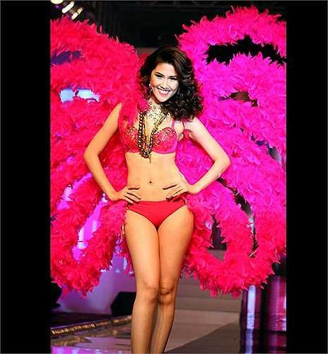 Chân dài Thu Hằng cũng khoe đường cong cơ thể với nội y và đôi cánh hồng, lấy ý tưởng từ các show diễn của Victoria's Secret. 