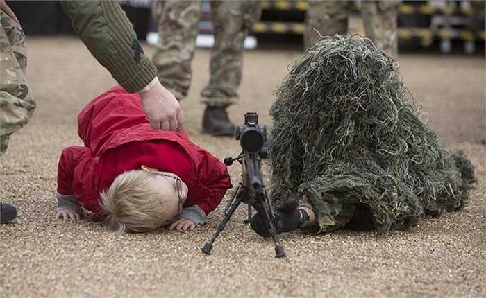 Cậu bé tò mò bên cạnh trang phục của một người lính Anh