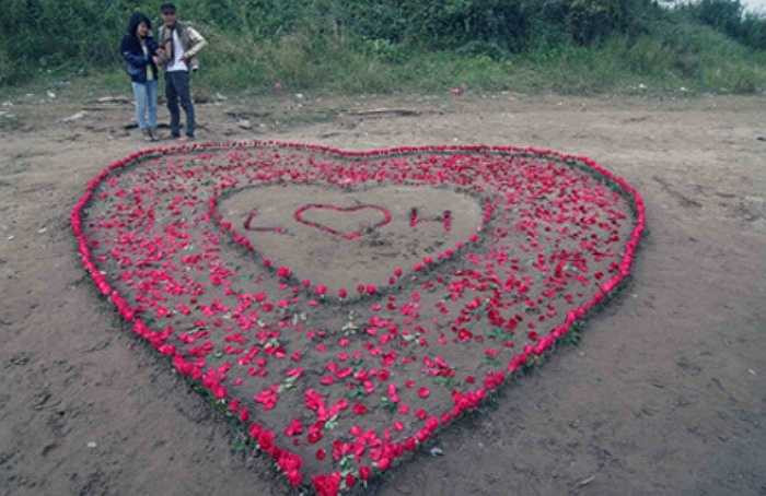 Những người dân ven bờ sông Hồng tiếp tục bất ngờ khi chứng kiến một chàng trai tỉ mẩn ngồi xếp 600 bông hoa hồng thành hình trái tim để tỏ tình. Bất chấp thời tiết còn lạnh giá, Lê Văn Long đã hình trái tim có lồng chữ đầu của hai người