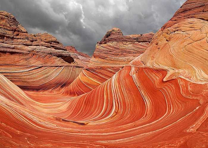 Vùng đá sa thạch độc nhất vô nhị có tên The Wave nằm trên sườn núi Coyote Buttes, giữa bang Utah và Arizona của Mỹ mang một vẻ đẹp vô cùng kỳ vĩ. Được hình thành từ những đụn cát hàng tỷ năm tuổi kết hợp với sự chuyển động và kết tủa của vật liệu oxy hóa như sắt và mangan bởi nước ngầm.