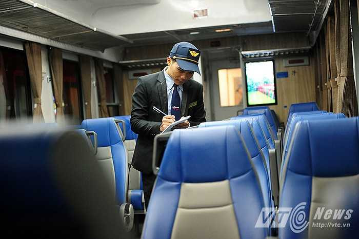 Anh Nguyễn Văn Uy (Nhân viên khách vận) đang kiểm tra số ghế mà hành khách đã đặt mua tại toa ghế ngồi mềm điều hòa.