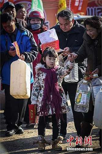 Mỗi người trên tay chuẩn bị can nhựa để lấy nước tương miễn phí