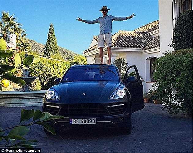 Một chàng trai con nhà giàu đăng hình chụp đứng trên chiếc xe Porsche Cayenne màu đen khi du lịch tới resort ở Tây Ban Nha