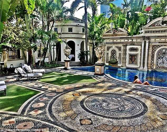 Một cô gái tóc đen đang nằm tắm năng bên bể bơi trong biệt thự ở bờ biển Miami