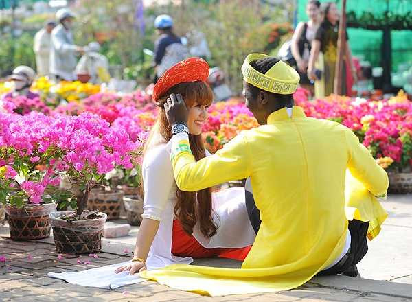 Đôi vợ chồng trẻ không ngại thể hiện tình cảm ở chợ Tết