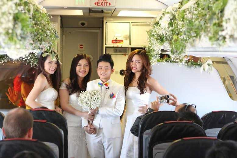 cặp đôi nắm tay hạnh phúc trên tàu bay