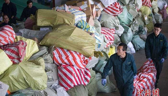 Các nhân viên bưu điện thành phố Thái Nguyên, tỉnh Sơn Tây đang sắp xếp lại đống bưu kiện chất thành đống lớn trong dịp nghỉ Tết Nguyên Đán.