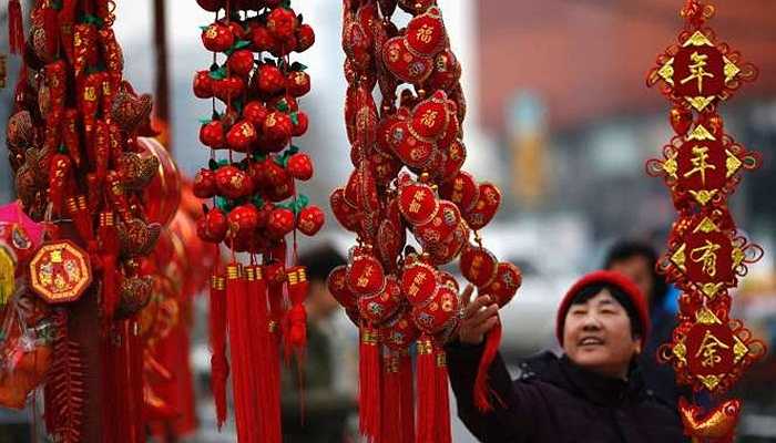 Một người phụ nữ đang ngắm nghía một đồ trang trí tại chợ ở Bắc Kinh, Trung Quốc