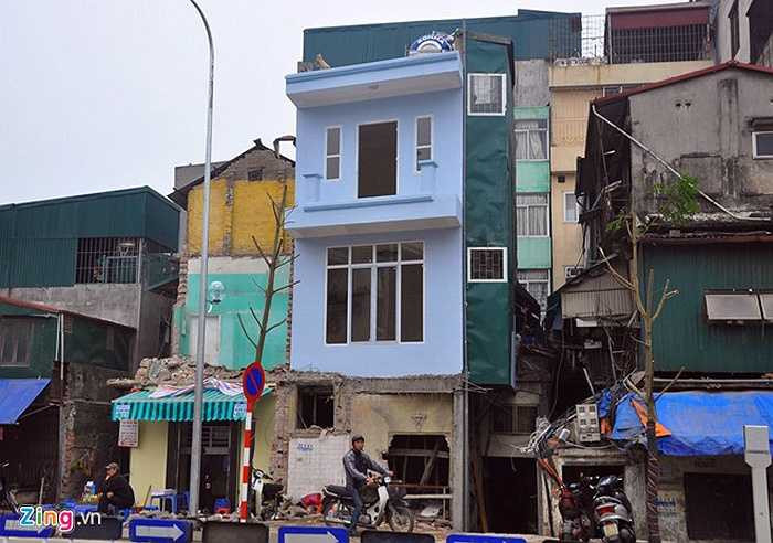 Ông Trường Giang, người dân sống trên phố Thanh Bảo cho hay, tuyến đường mới đi vào hoạt động chỉ vài ngày nên nhiều gia đình giáp ranh với chỉ giới làm đường không kịp sửa sang nhà cửa. Tuyến đường mở rộng, có hộ bị cắt ngang, cắt 2/3, thậm chí chỉ còn nửa mét không thể tiếp tục sinh hoạt phải phá bỏ. Trong ảnh: ngôi nhà 3 tầng ngã tư Thanh Bảo - Trần Phú phải phá dỡ vì còn quá mỏng, ngôi nhà màu xanh bên cạnh dù sửa sang lại vẫn méo mó.