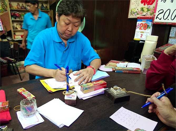 Đại diện chùa Bà viết biên nhận của người đi cúng