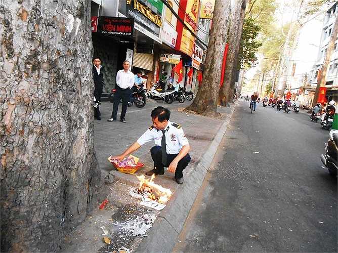 Đốt vàng mã khai trương bán hàng đầu năm. Ảnh: Phan Cường