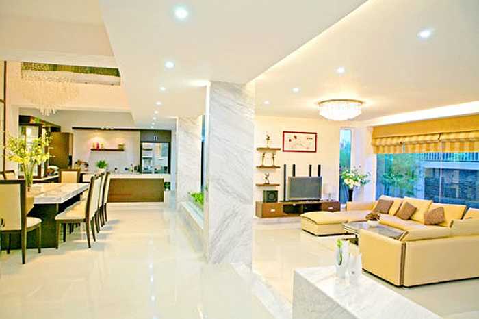 Phòng khách và phòng ăn được ngăn cách bởi một bức tưởng nhưng có nhiều khoảng trống tạo không gian thoáng đãng.