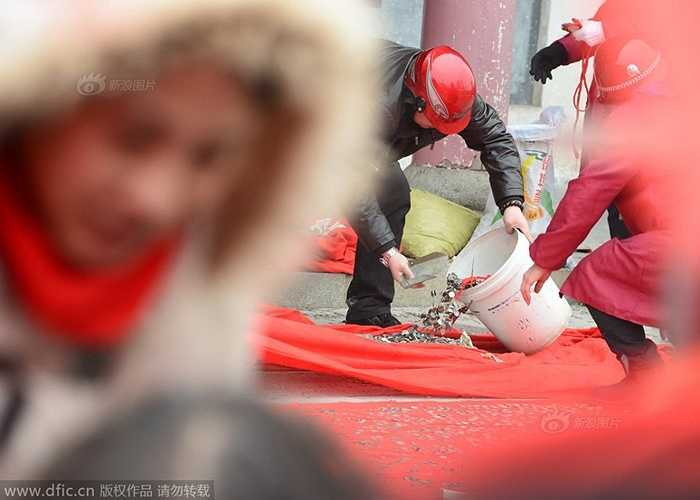 Số lượng tiền xu quá nhiều, các nhân viên thuộc ban quản lý đã phải đội mũ bảo hiểm để dọn dẹp số tiền xu trước sảnh và từ trên mái nhà rơi xuống