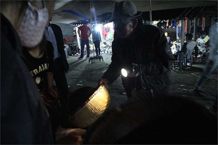 Ở một góc khuất, ông cụ này còn soi đèn pin để lựa chọn những chiếc thúng ưng ý cho gia đình.