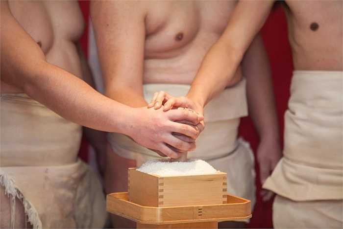 Tấm bùa may mắn được đặt trong hộp gạo