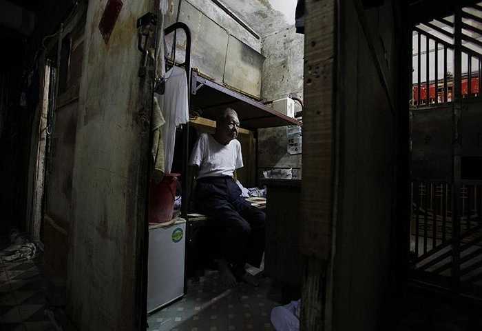 Ông Huang cùng vợ ngồi trên giường đặt chật cả căn phòng 4m2 được thuê hơn 1000 nhân dân tệ/tháng