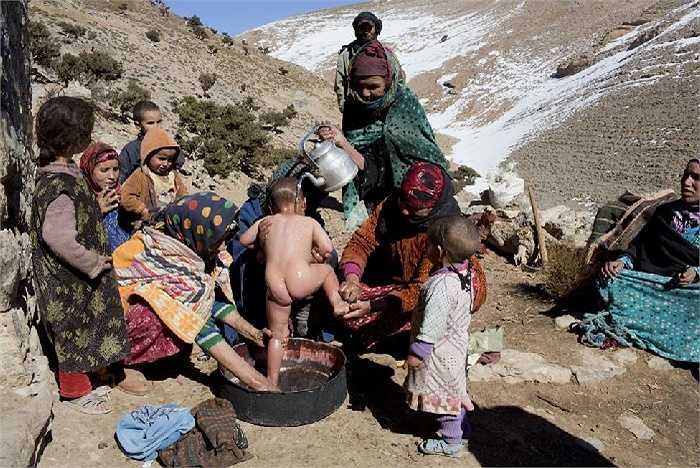Phụ nữ Berber tắm cho một đứa trẻ trong làng Ait Sghir ở vùng núi Atlas, Morocco. 