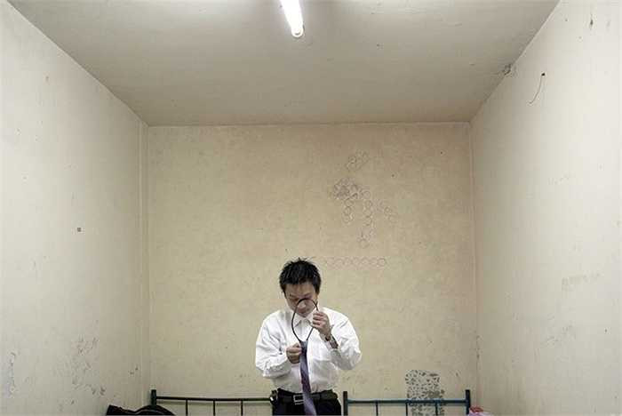 Anh chàng He Bing, 23 tuổi, đang thử một bộ quần áo để chuẩn bị cho buổi phỏng vấn làm nhân viên bán bảo hiểm. Bing mới đến từ thành phố Trùng Khánh và đang sống chung trong một căn hộ tầng hầm nằm ở trung tâm Bắc Kinh với hai người khác.