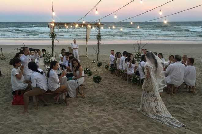 Không gian tiệc cưới được trang trí đơn giản trên bãi biển Phan Thiết, lấy màu trắng làm chủ đạo.